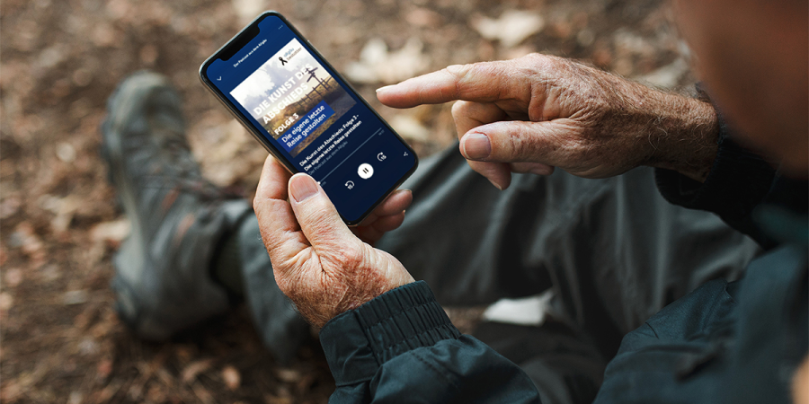 Ein Mann nutzt sein Smartphone, um einen Podcast zu hören.