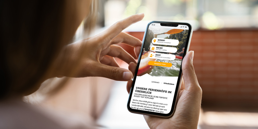 Eine Frau sieht sich auf ihrem Smartphone die Website von Landorado an
