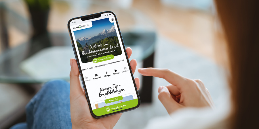 Eine Frau sieht sich auf ihrem Smartphone die Website von Landsichten