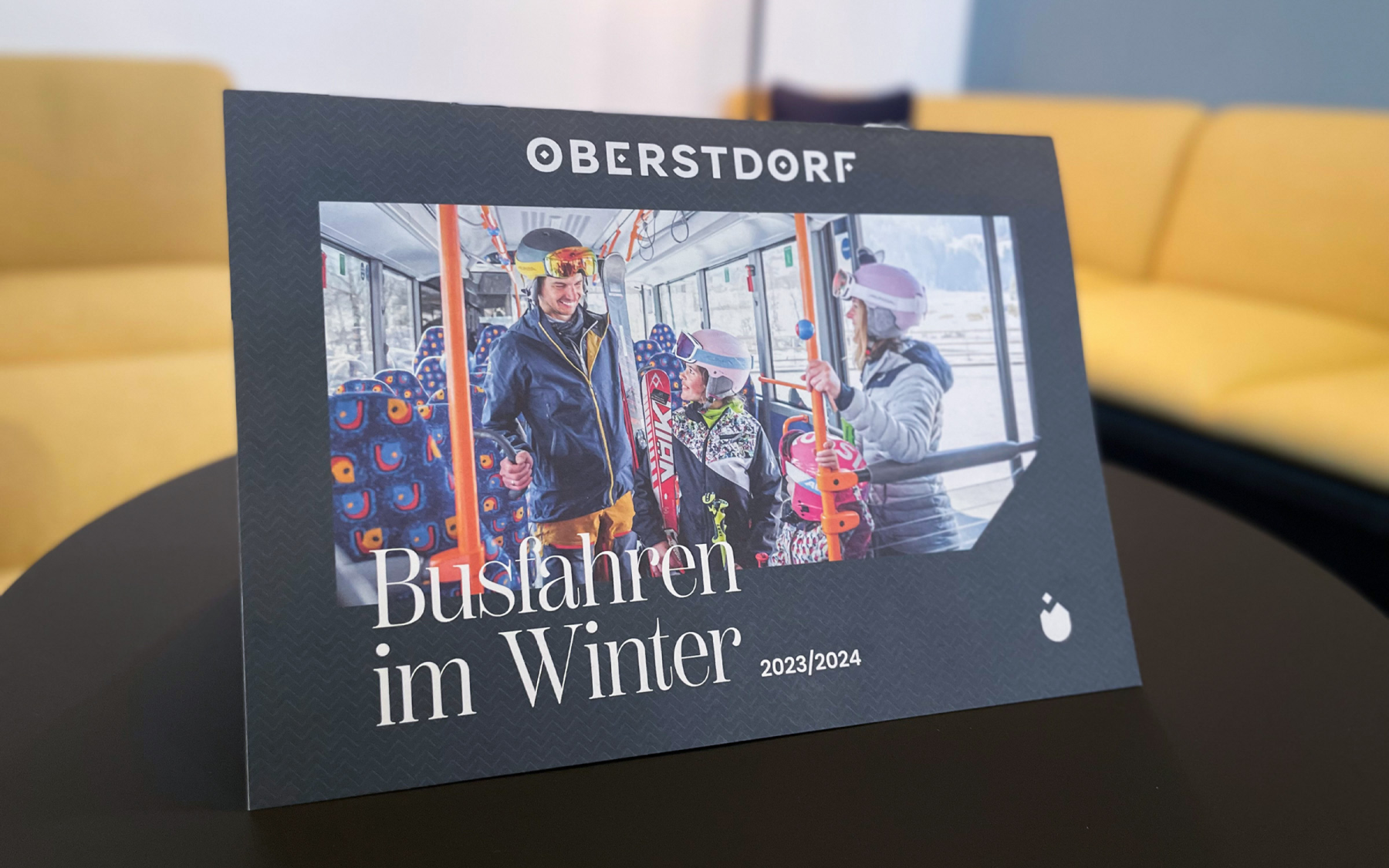 Die Busbroschüre von Oberstdorf steht aufgeklappt auf einem Tisch